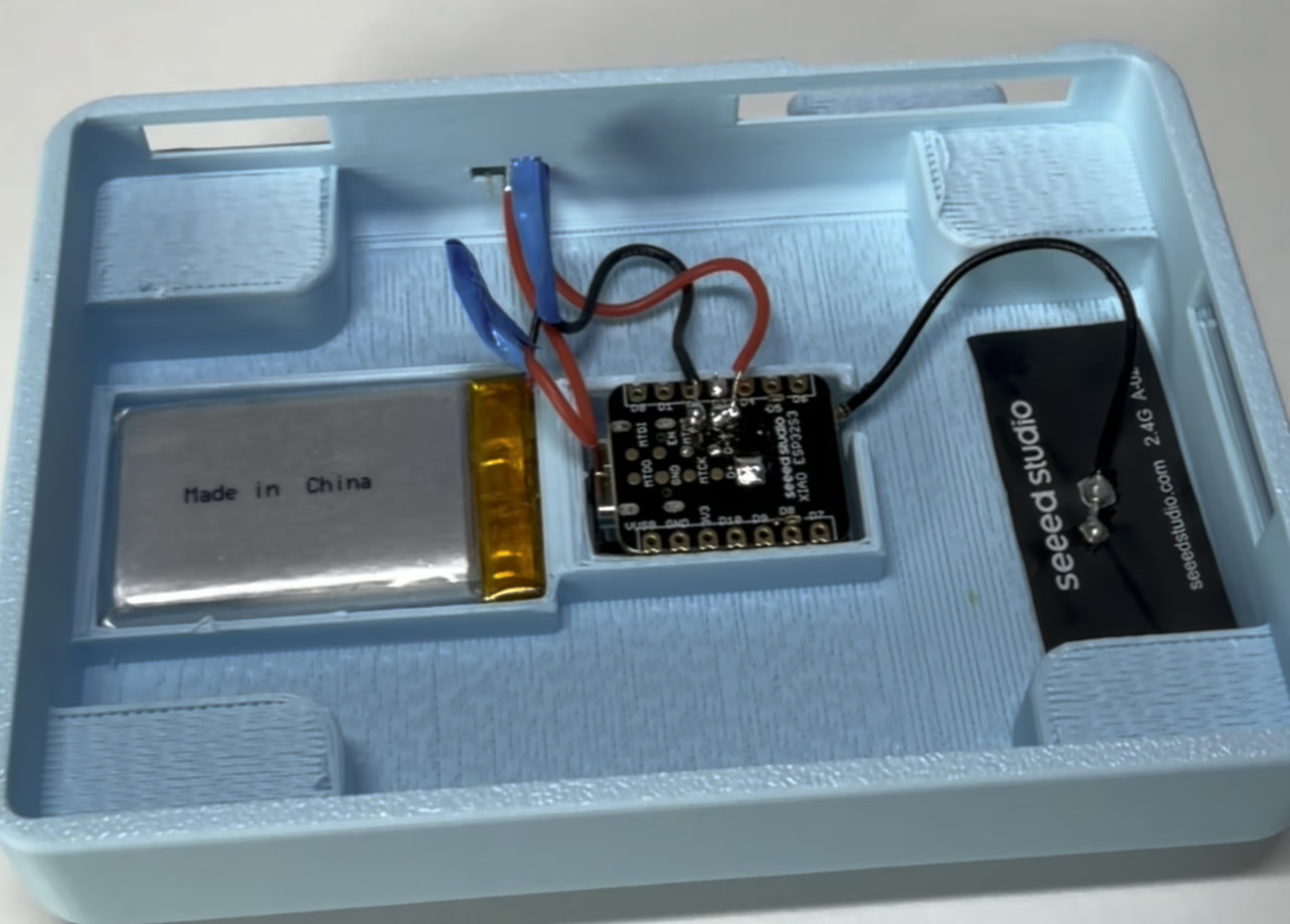 The finished camera half in the shell: LiPo, the XIAO wired through the switch, and the antenna.