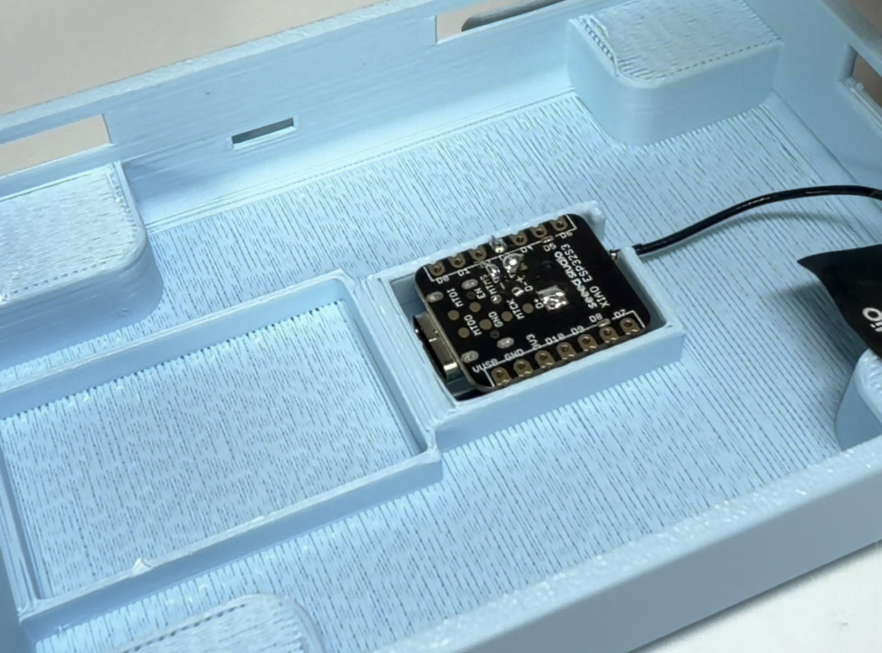 The XIAO seated in its recess, antenna routed off to the side.