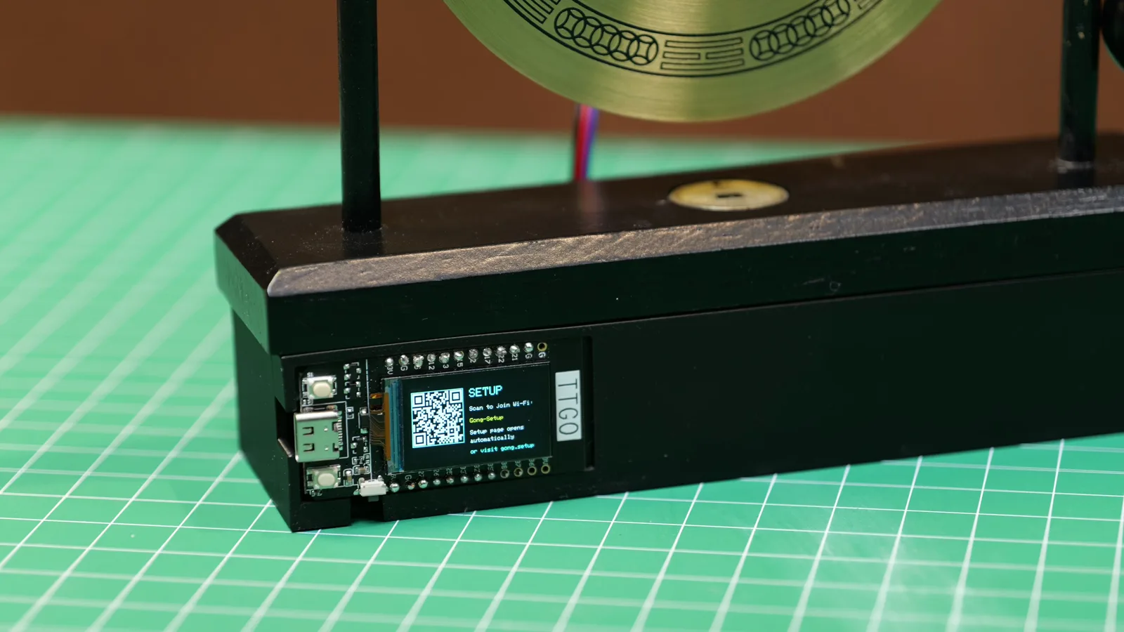 The finished case with the board's screen showing the setup QR code.