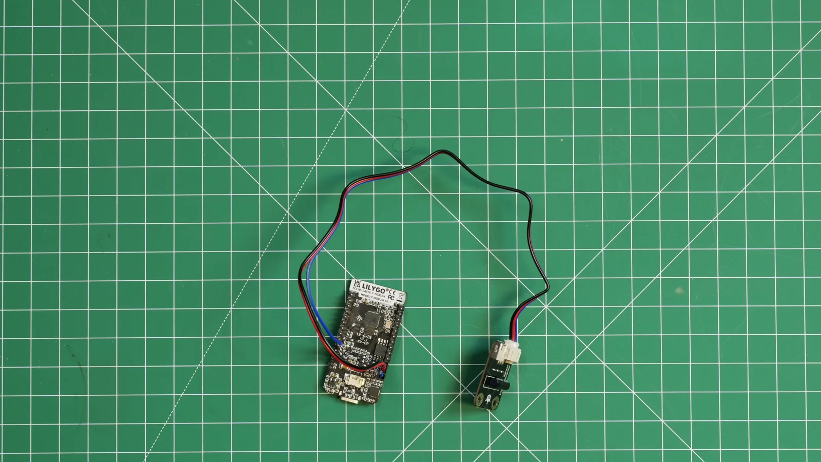 The board and the vibration sensor, wired up on the cutting mat.