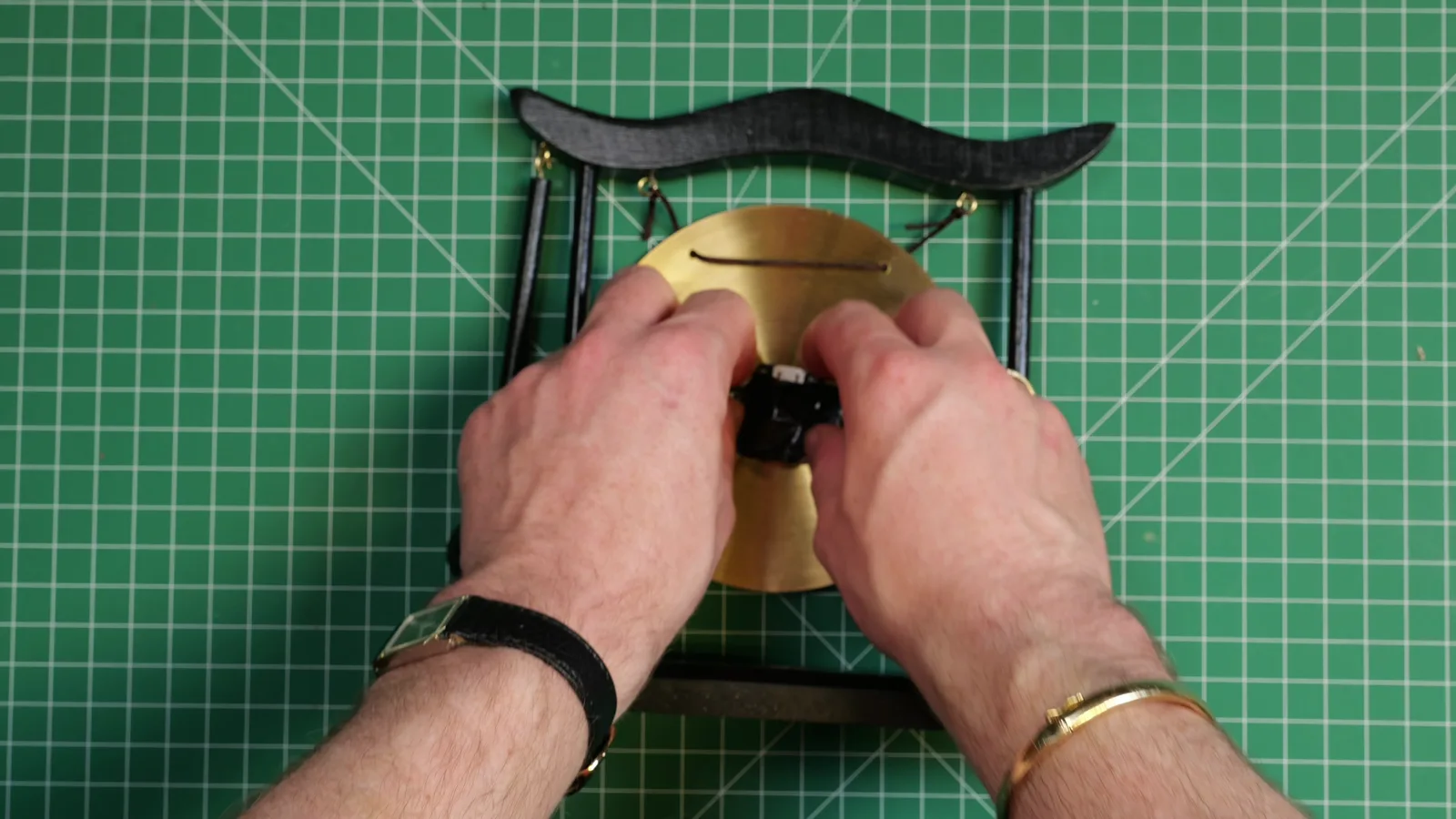 Taping the vibration sensor to the back of the gong for a first test.